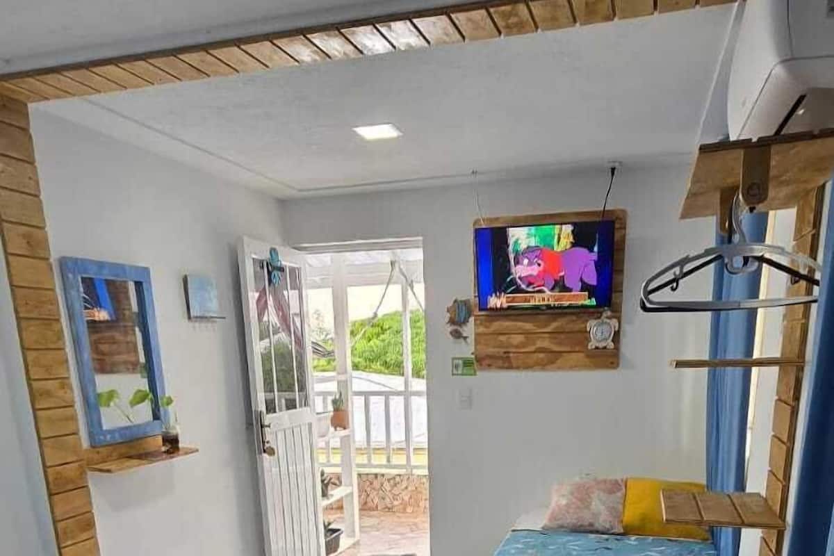 A room with two beds, a TV, and a window with curtains.