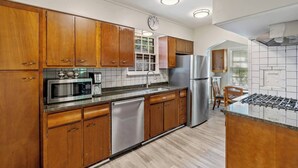 Une cuisine moderne avec des meubles en bois, des appareils en acier inoxydable et une cuisinière intégrée.