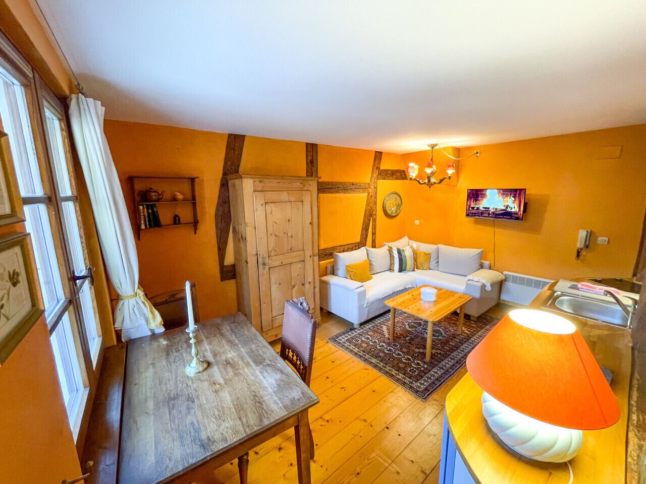 Una sala de estar acogedora con una mesa de madera, un sofá y un televisor.