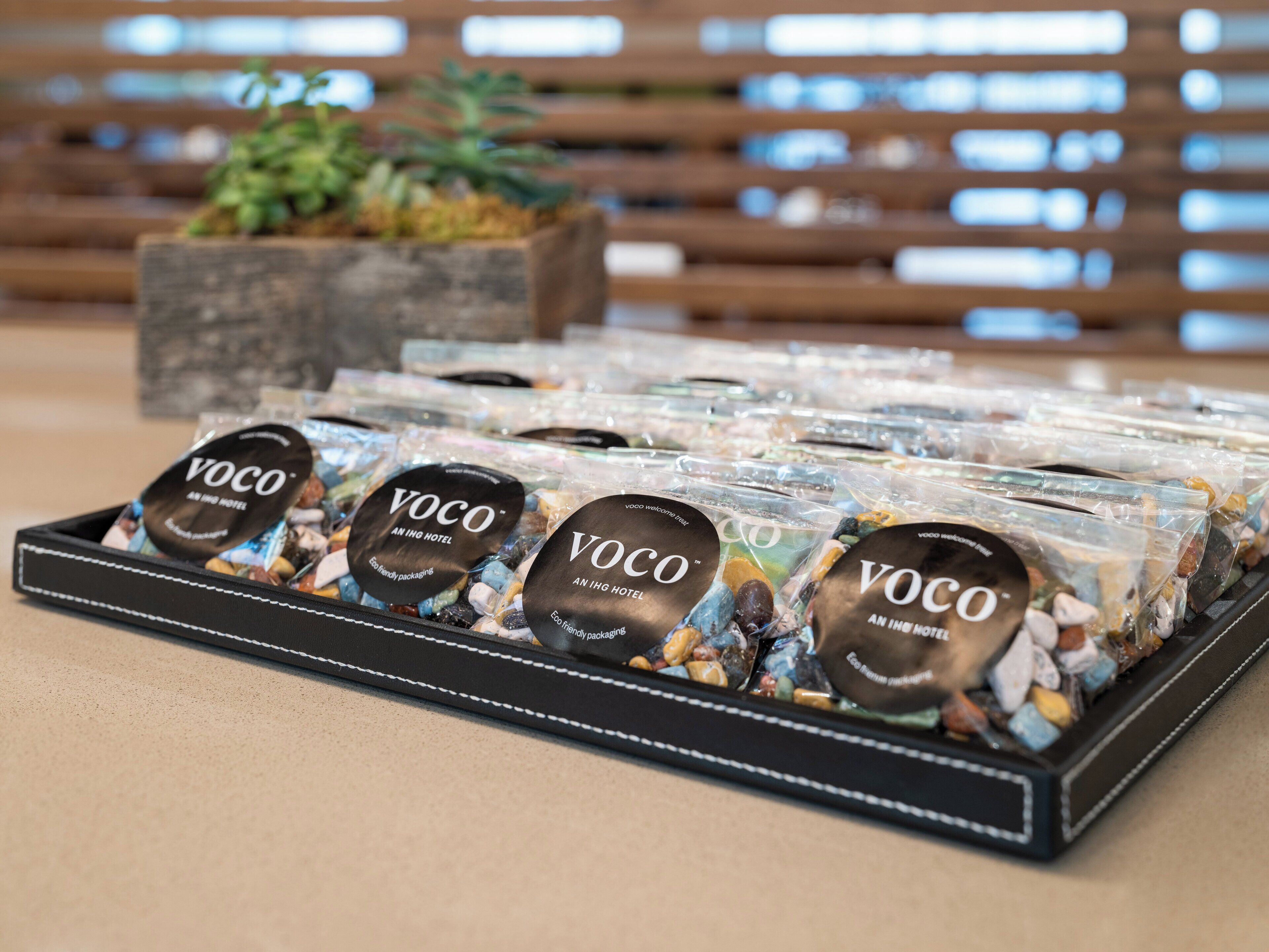 Presentación de productos empaquetados con la etiqueta 'VOCO', destacando el embalaje ecológico.