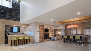 A spacious hotel lobby with a bar area, seating, and a fireplace. - voco Moab by IHG (Moab)
