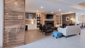 A modern living room with a fireplace, seating area, and built-in shelves. - voco Moab by IHG (Moab)