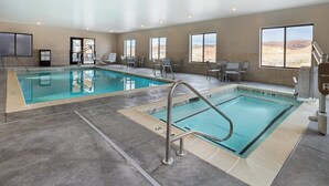 An indoor swimming pool with two lanes, sunlit windows, and a desert view. - voco Moab by IHG (Moab)