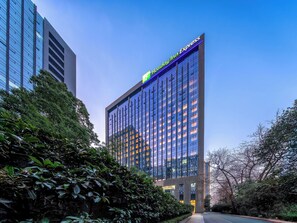 Un immeuble de grande hauteur avec une enseigne bien visible pour Holiday Inn Express.