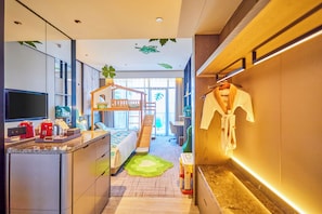 A modern hotel room with a kitchen area, a small play area with a slide, and a large window providing natural light. - Crowne Plaza Quzhou by IHG (Quzhou)
