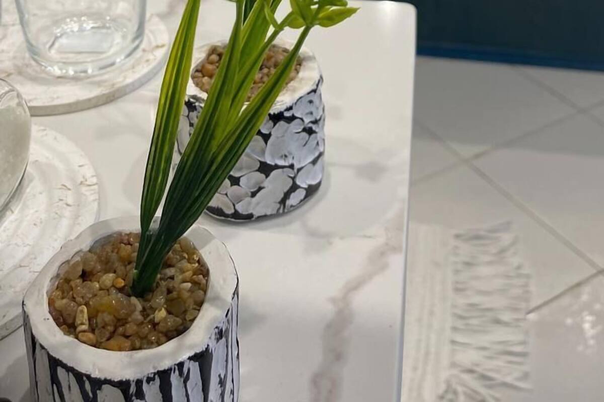 Une chambre à coucher avec un lit, une table de chevet et une plante en pot.
