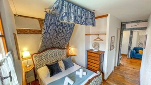 Een slaapkamer met een bed, nachtkastjes, een kast en een hanglamp.