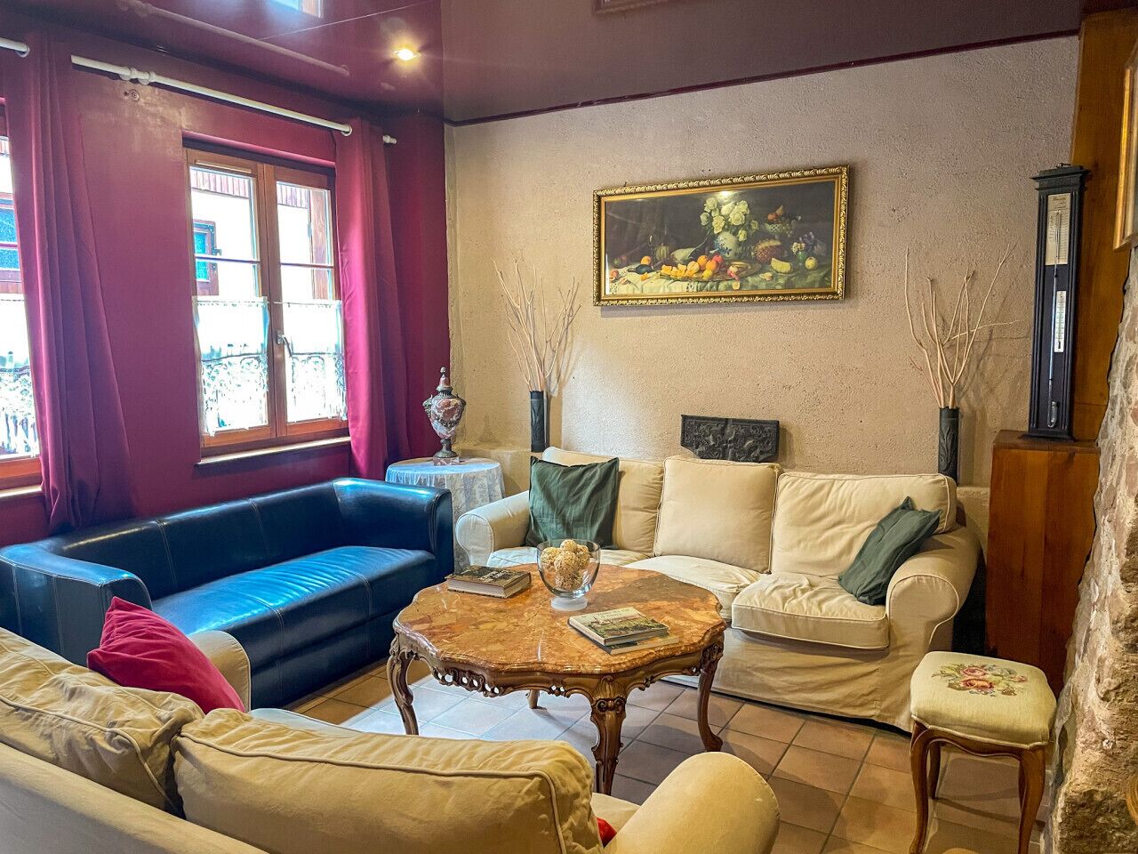 Un salón con un sofá azul, un sofá color beige y una mesa de centro de madera con libros.