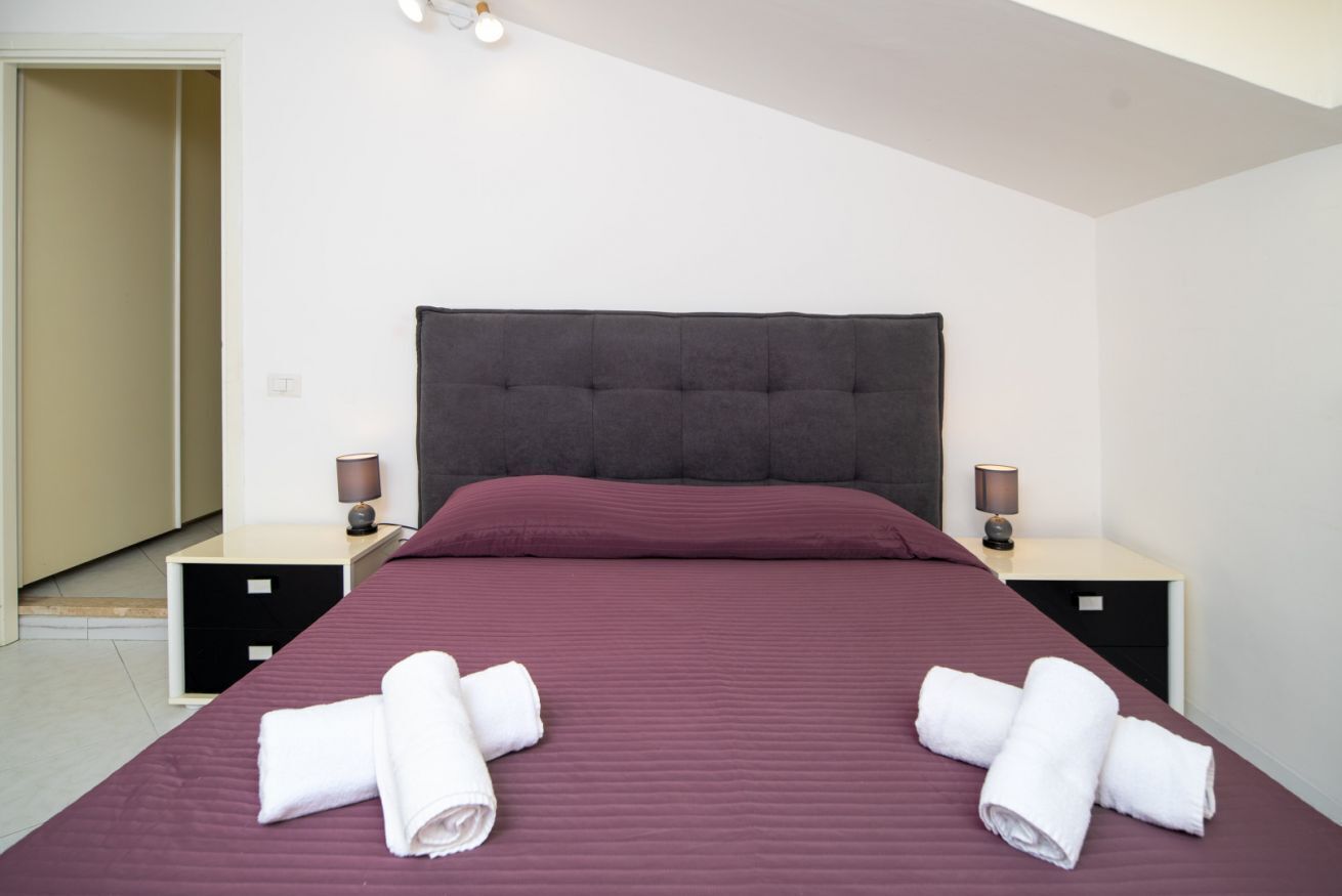 Ein Hotelzimmer mit einem Bett, zwei Nachttischen und einer Tür.