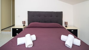 Ein Hotelzimmer mit einem Bett, zwei Nachttischen und einer Tür.