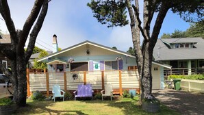 A house with a fenced yard, a covered porch, and a small garden area. - Superb 3-bedroom house with WiFi in Neskowin.   (Neskowin)