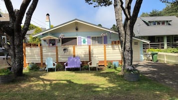 A house with a fenced yard, a covered porch, and a small garden area.