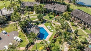 Ein Resort mit mehreren Gebäuden, einem Swimmingpool und üppiger Bepflanzung.