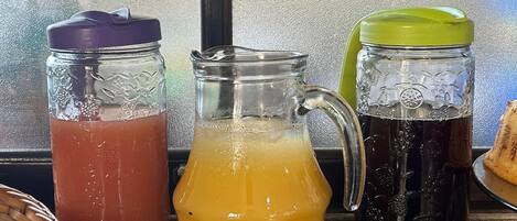 Three glass containers with different colored liquids on a kitchen counter.
