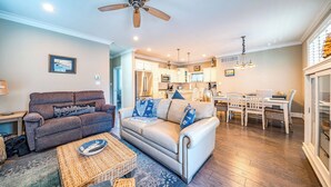A living room with a sofa, a coffee table, and a dining area with a table and chairs.