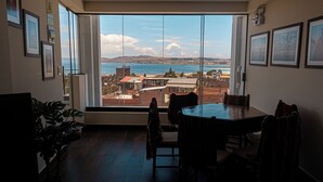 Un área de comedor con un ventanal grande con vistas a la ciudad y al agua.