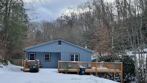 A blue cabin with a wooden deck and a covered porch area. - Mountain home in Newland (Newland)