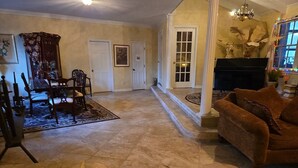 A spacious living room with a fireplace, a dining area with a table and chairs, and a cozy seating area with a sofa. - The Art History House, indoor heated pool, 3 bedrooms, with two kitchens (Goose Creek)