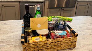 Une cuisine dotée d’un plan de travail en marbre, d’appareils électroménagers en acier inoxydable et d’une fenêtre avec des stores.