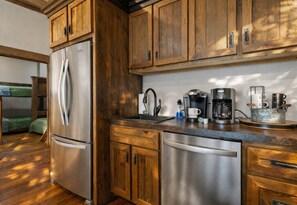 A kitchen with wooden cabinets, stainless steel appliances, and a coffee maker.