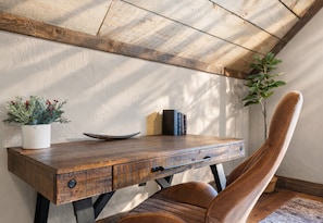 A rustic wooden desk with a plant, books, and a bowl.