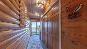 A log cabin interior with a wooden floor, a geometric patterned rug, and a welcome sign on the wall. - Beautiful home on Lake Pokegama! (Grand Rapids)