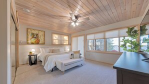 A bedroom with a bed, bedside table, lamp, and a ceiling fan. - Beautiful home on Lake Pokegama! (Grand Rapids)