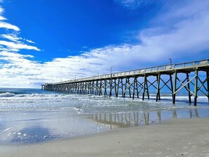 Un muelle que se adentra en el océano bajo un cielo despejado.
