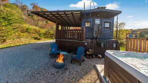 Une cabane dotée d’un bain à remous, d’un espace extérieur aménagé et d’un foyer.