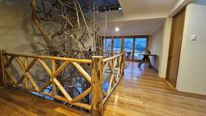 A wooden staircase with a railing leading to a balcony with a view of a snowy landscape. - Amaru TreeHouse (Cusipata)