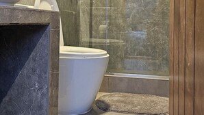 A modern bathroom with a glass-enclosed shower, a marble sink, and a toilet. - Amaru TreeHouse (Cusipata)