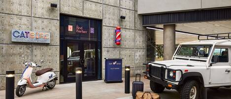 A modern building with a concrete facade, a sign for 'CATBIRD' on the left, and a 'Red Barber' entrance.