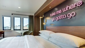 Ein Hotelzimmer mit Bett, Schreibtisch und Blick ins Freie.