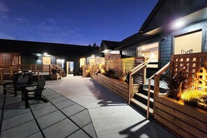 A modern building with a wooden facade, outdoor seating, and a staircase leading to the entrance. - The Berry @ The Louie Boutique Motel, Walk to Everything! Dog Friendly! (Newport)