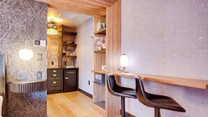 Eine moderne Bar mit einer Holztresen, zwei schwarzen Barhocker und einer Wand mit Muster.
