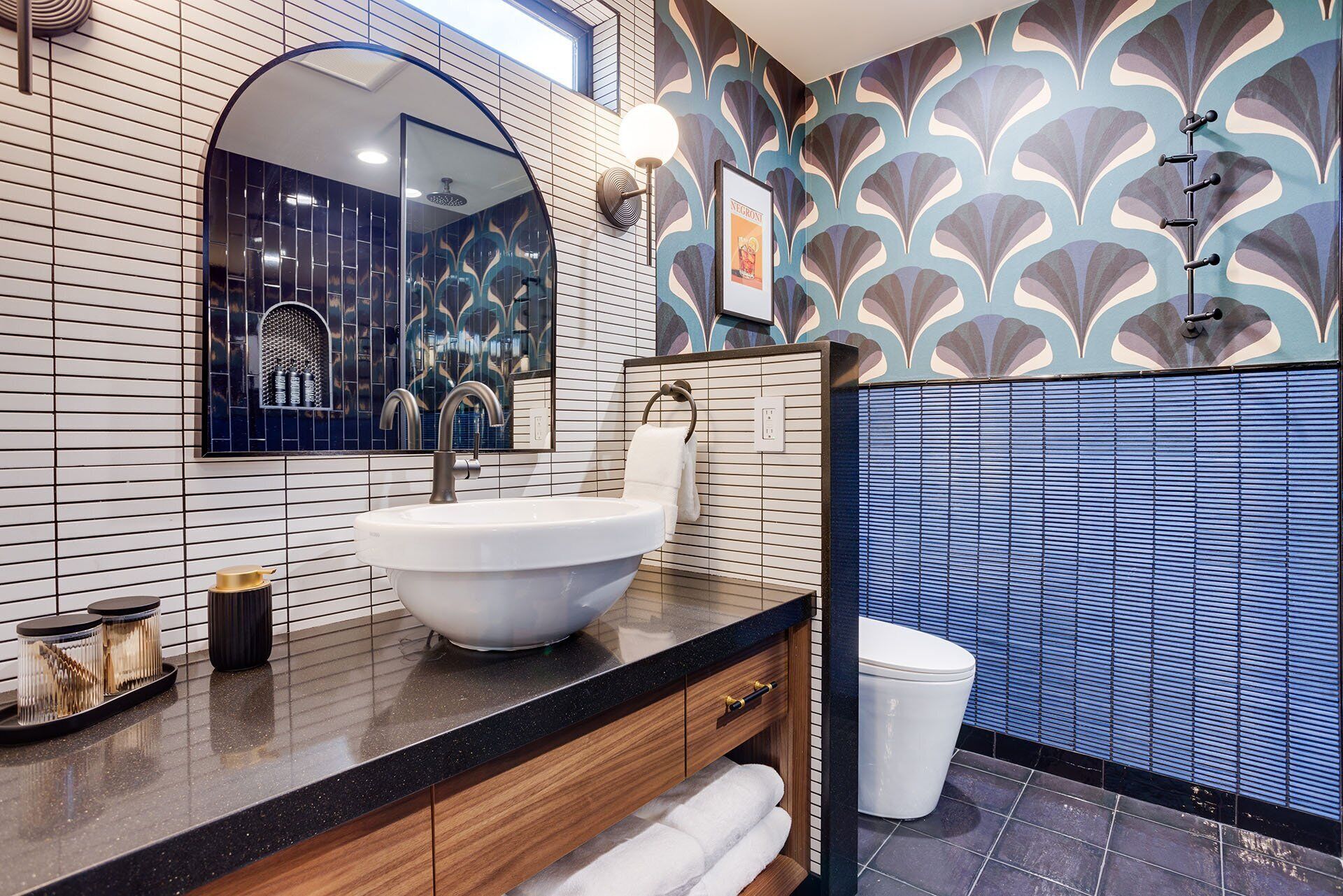 Une salle de bain moderne avec un grand lavabo, un miroir et un espace douche.