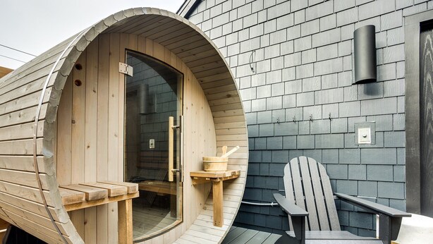 A wooden sauna with a curved entrance, a wooden bench, and a sauna chair outside. - The Reed @ The Louie Boutique Motel, Private Sauna! Walk to Everything! (Newport)