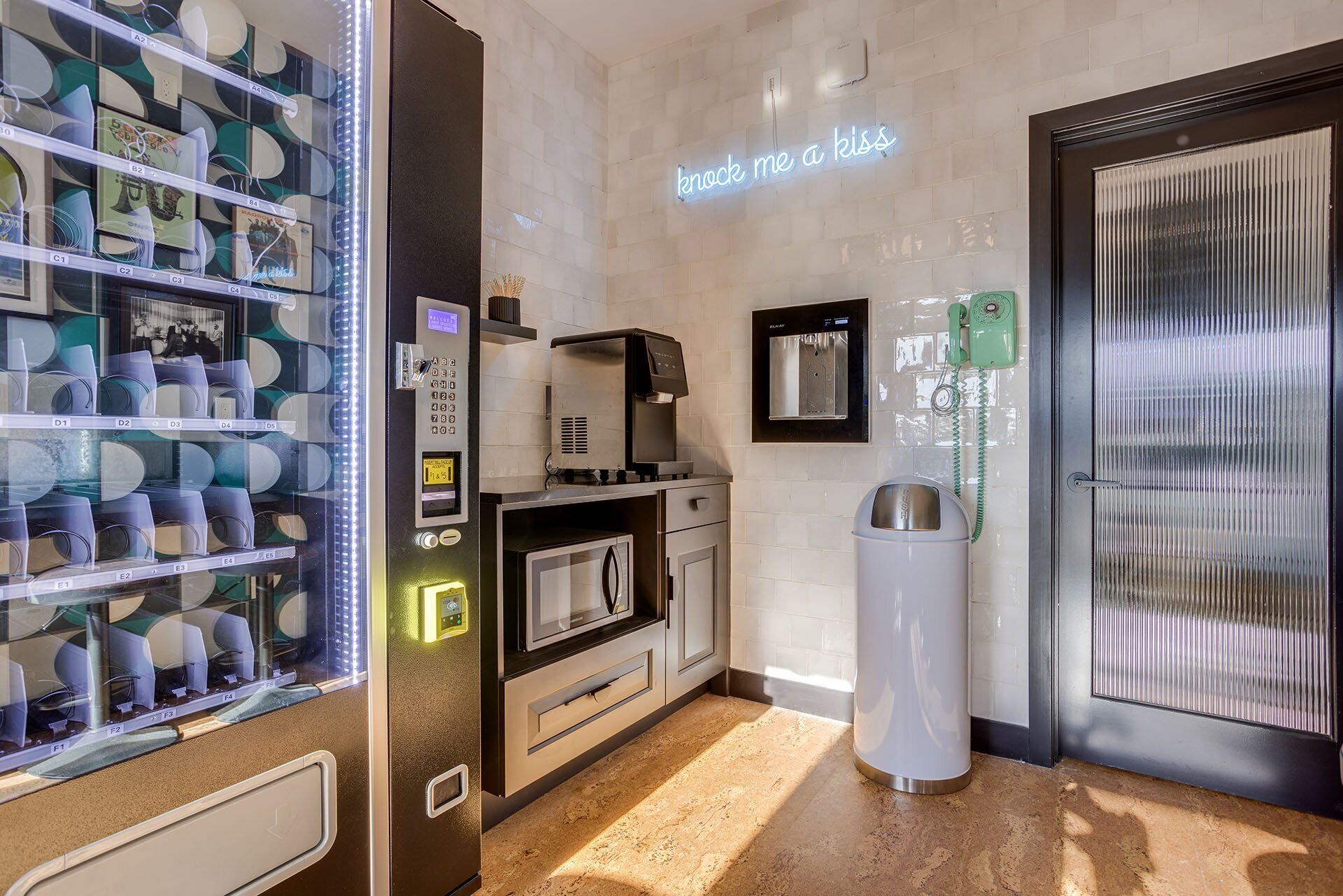 Una cocina moderna con cafetera, dispensador de agua y contenedor de basura.