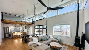Un amplio salón con un sofá modular grande, una mesa de comedor y una chimenea.