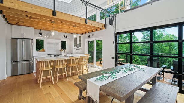 Una cocina moderna con vigas de madera, una isla grande y un comedor con banco.