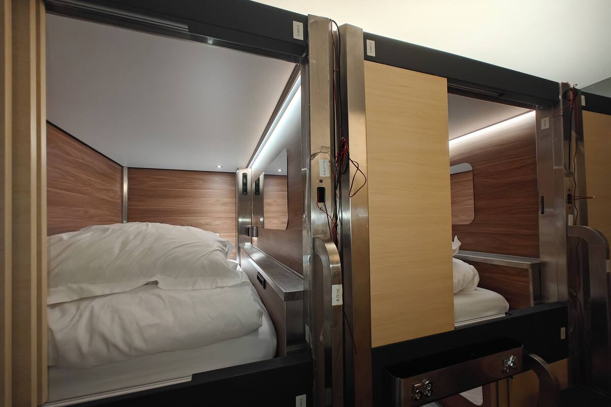 A bunk bed room with wooden walls and a small desk.