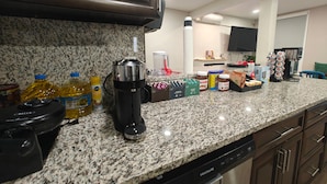 A kitchen with granite countertops, a coffee maker, and various food items. - I Street Capsule Hostel (Washington)