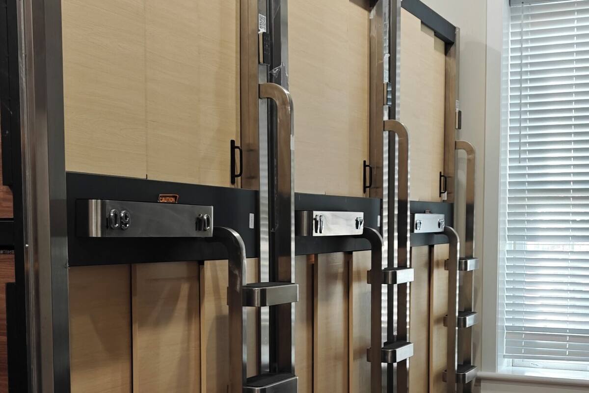 A row of lockers with a metallic frame and wooden doors, a QR code, and a shoe rack with a pair of shoes on the floor.