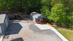 Une petite cabane à un seul étage, dotée d’un porche et d’une allée en gravier qui y mène.