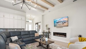 Ein modernes Wohnzimmer mit einer schwarzen Ledersofa, einem Holztisch und einem Kamin.