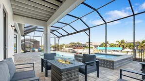 Ein überdachter Außenbereich mit Pool, Sitzgelegenheiten und einer Feuerstelle.