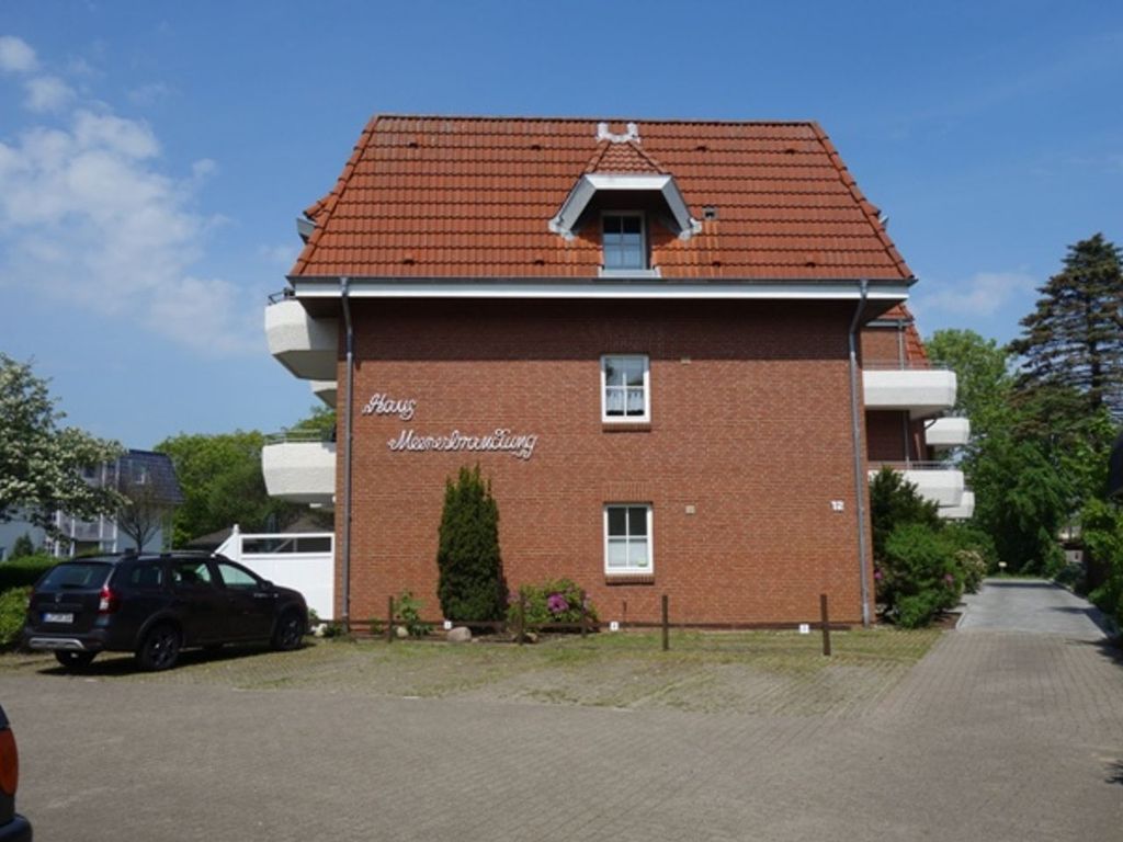 Ein zweistöckiges Backsteingebäude mit rotem Ziegeldach, einem kleinen Balkon und einem Schild mit der Aufschrift "Haus Möwenbrückling".