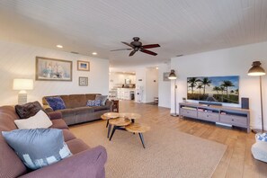 A living room with a sofa, coffee table, and television.