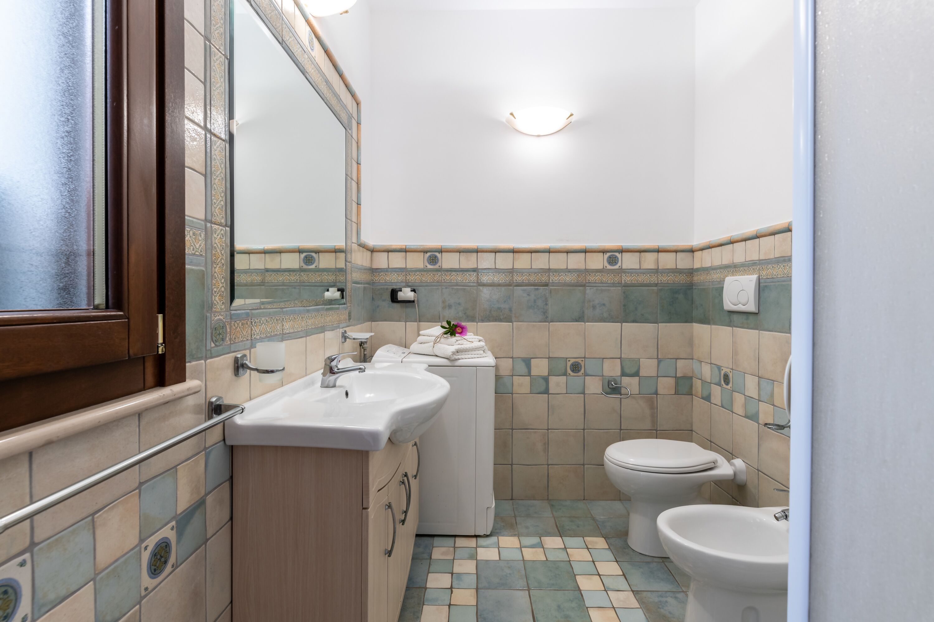 A bathroom with a sink, toilet, and mirror.