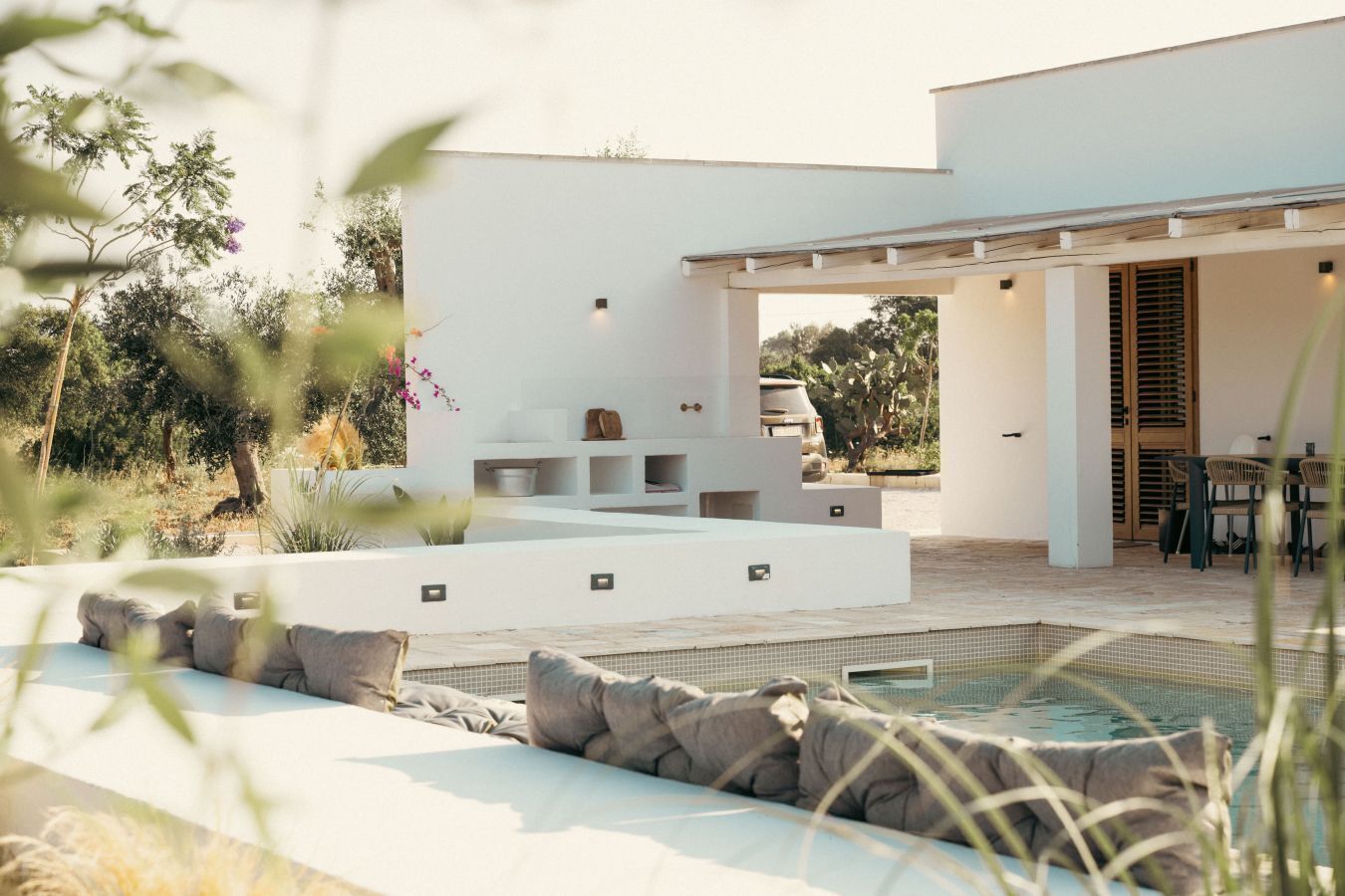 Un'area piscina moderna all'aperto, con zona relax e patio coperto.
